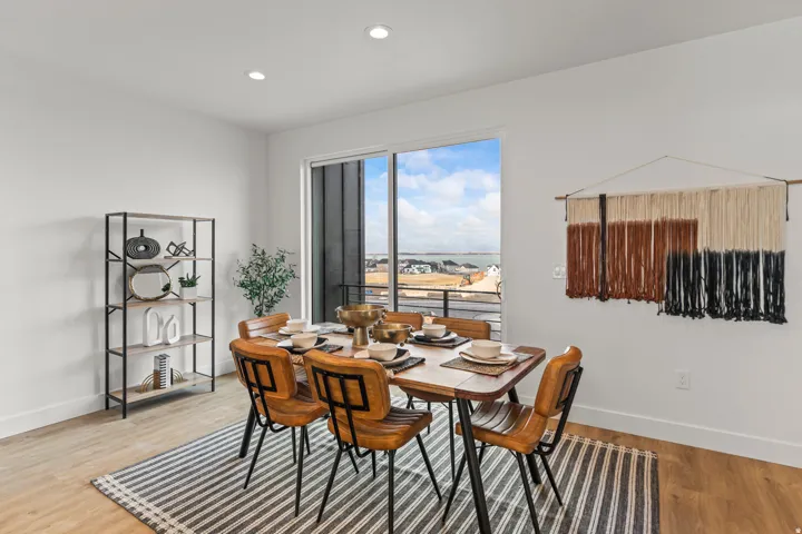 Spacious dining area featuring wood-finish flooring, recessed lighting, and a large sliding glass door
