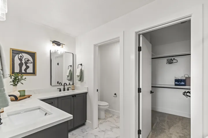 Double vanity with white countertops, dark gray cabinetry, and black hardware