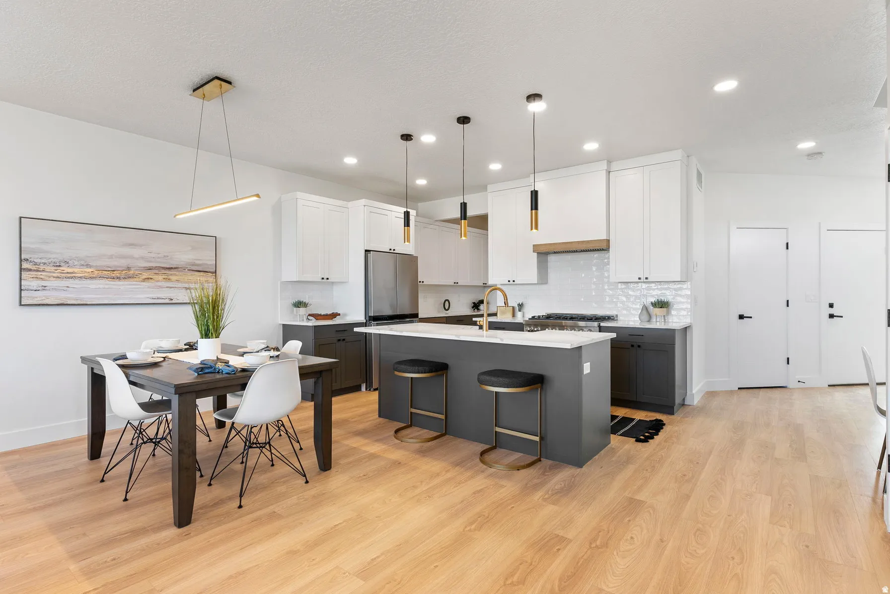 Open-concept kitchen with a large island, stainless steel appliances, and a tile backsplash