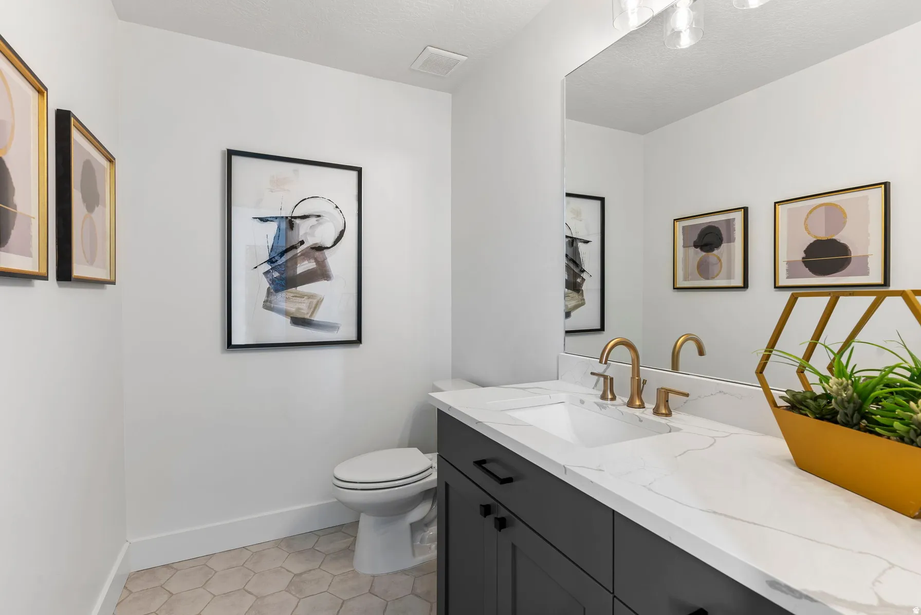Vanity with an integrated sink, gold-finish faucet, and white countertop
