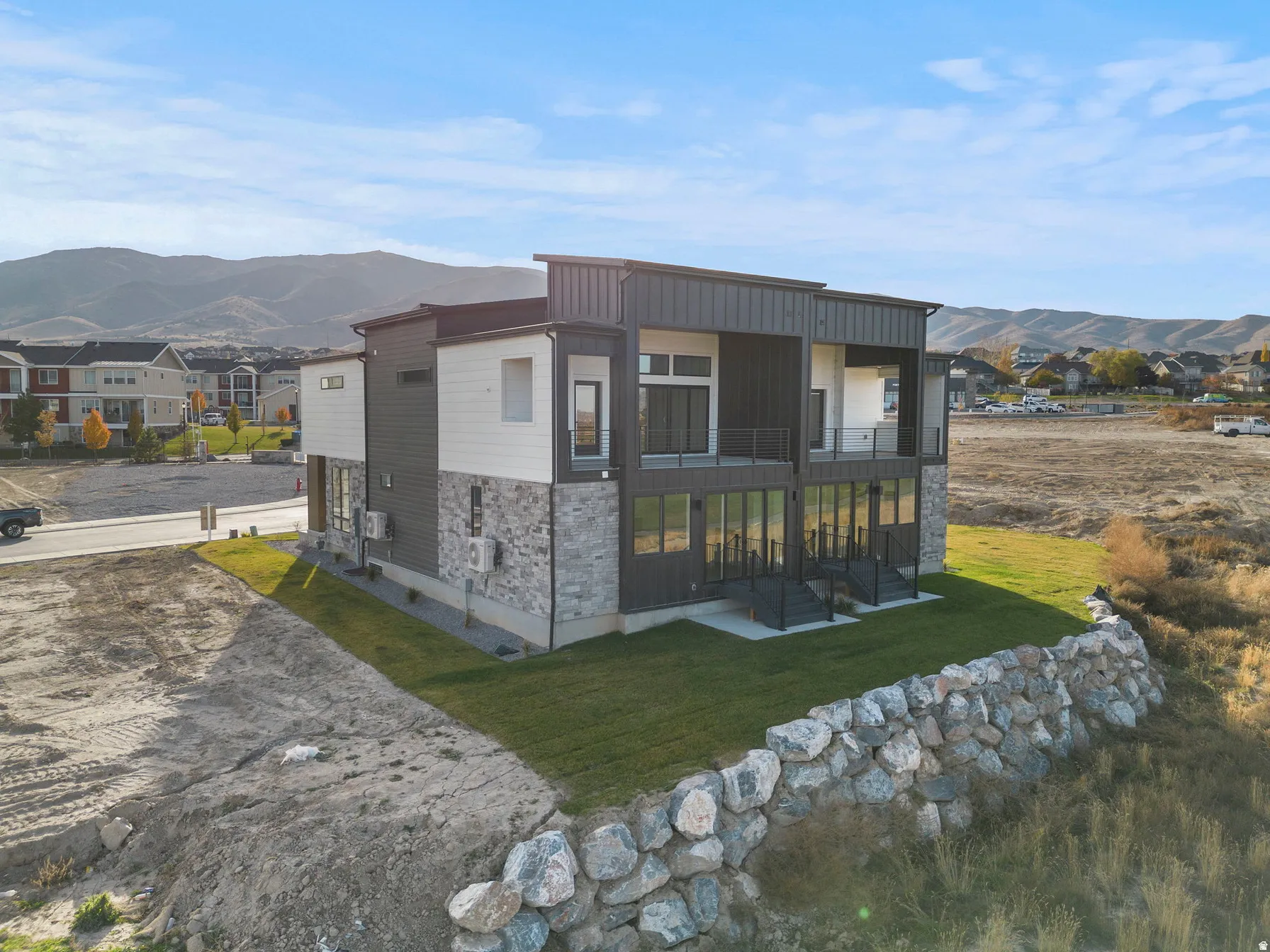 Contemporary exterior with a multi-level design, featuring stone and horizontal siding accents