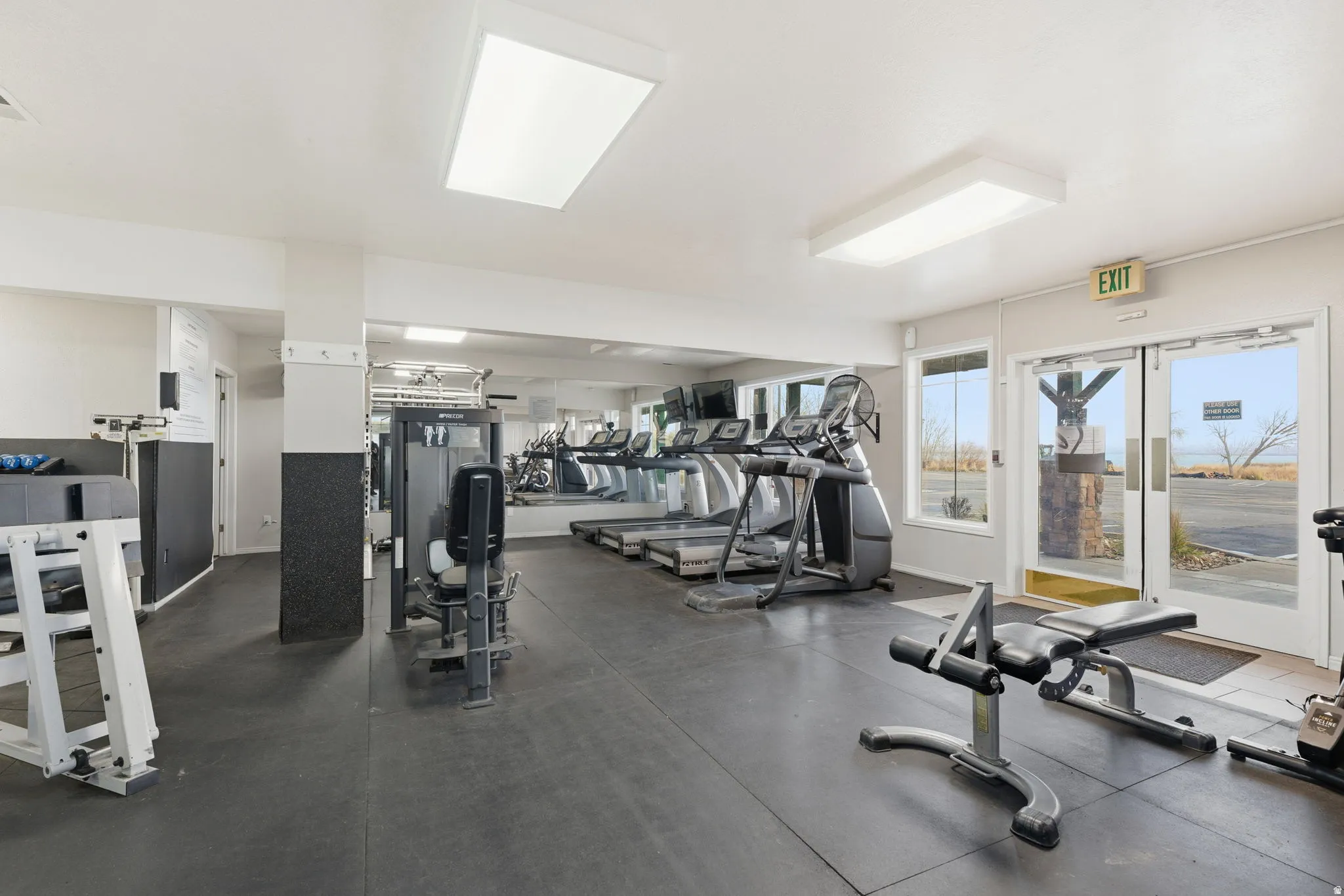 Fitness center featuring rubber flooring and mirrored walls