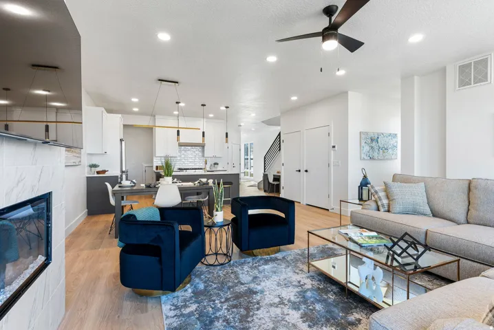 Open-concept living space with wood-finish flooring, a contemporary fireplace, and recessed lighting