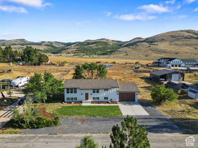 Contemporary residence featuring a two-car garage, concrete driveway, and expansive front lawn