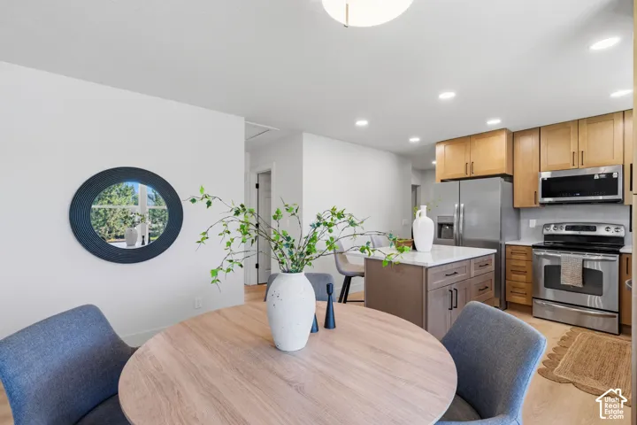 Kitchen featuring stainless steel appliances, wood-finish cabinetry, and a center island with a light-toned countertop
