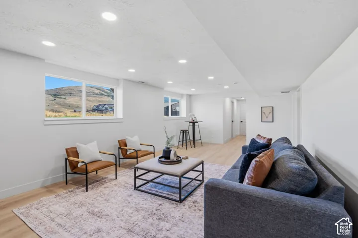 Recessed lighting, wood-finish flooring, multiple windows, and white walls