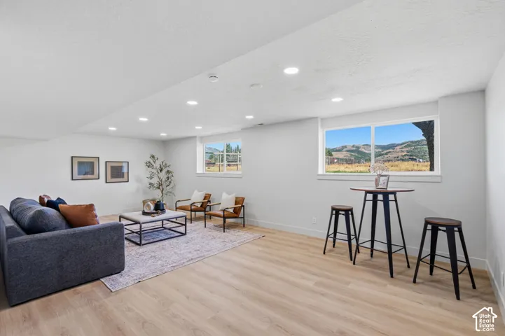 Recessed ceiling lighting illuminates the spacious interior, featuring light wood-finish flooring and white walls