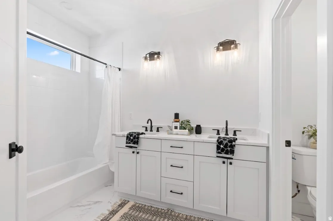 White vanity with dual sinks, black faucets, and black hardware