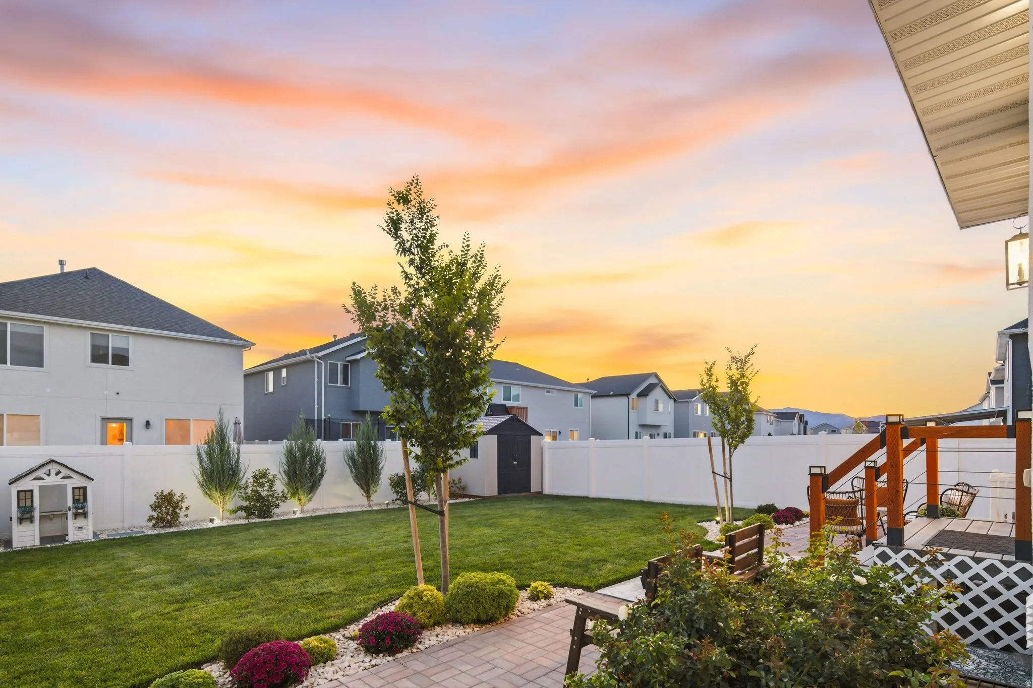 Fully fenced and landscaped back yard with brick paver patios and storage shed