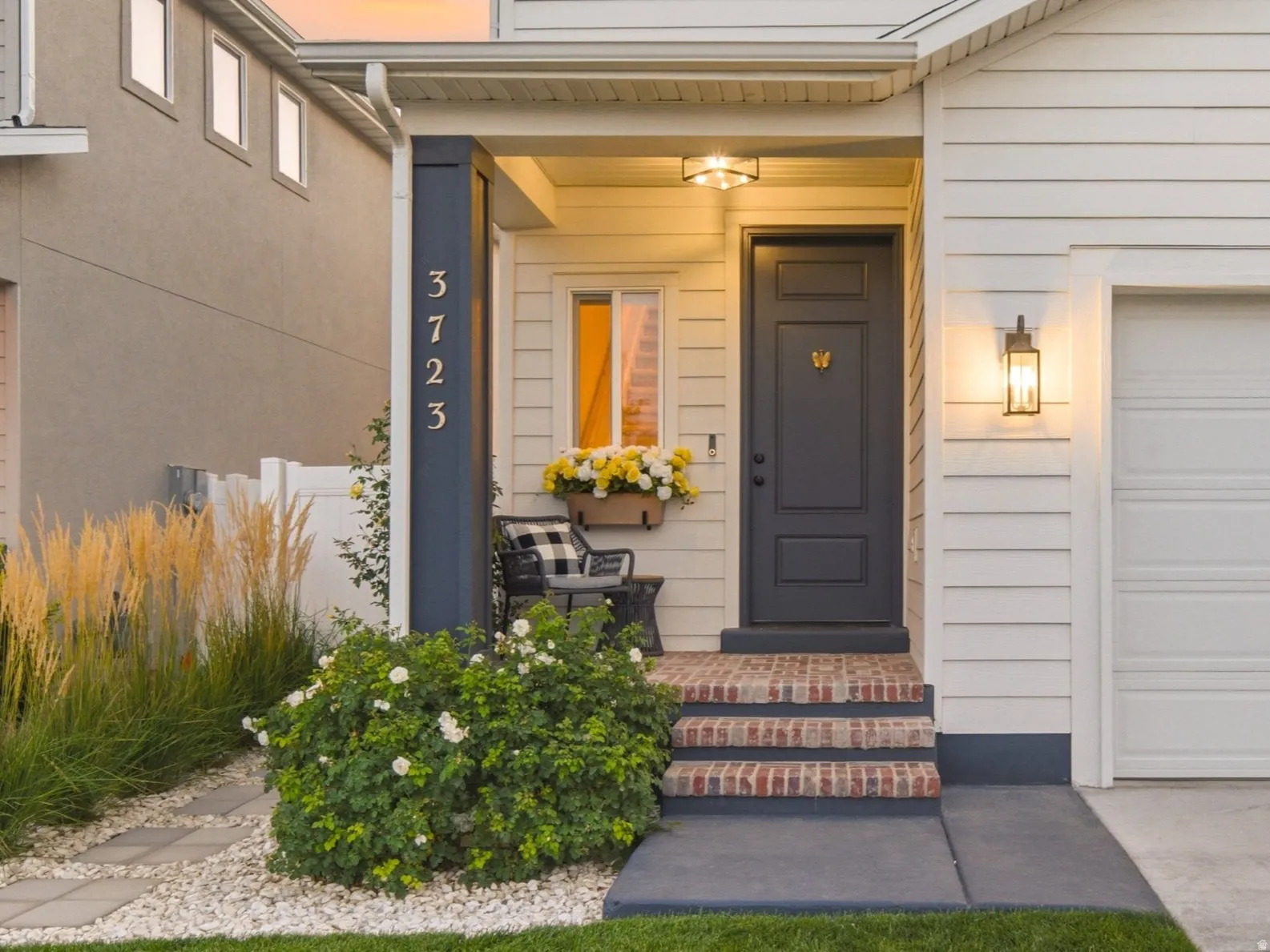 Enchanting entrance with upgraded lighting, landscaping, and brick paved steps and porch