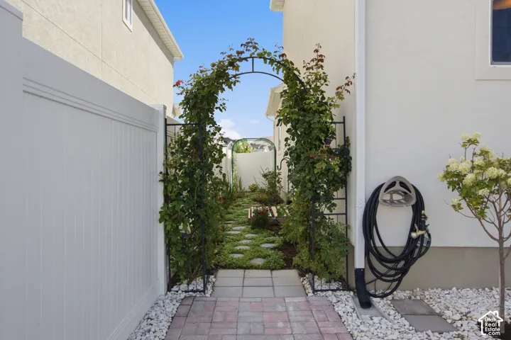 Enchanting private side yard/ garden with a climbing plant archway and stepping stone pathway.