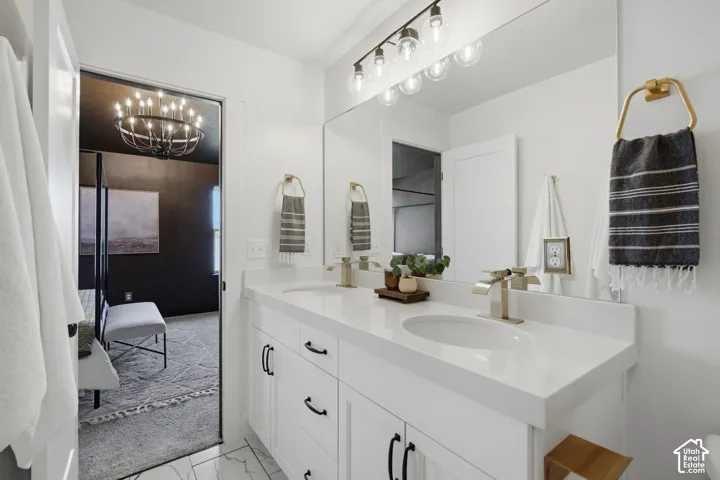 Dual vanity with white cabinetry, matte black hardware, and brushed gold faucets