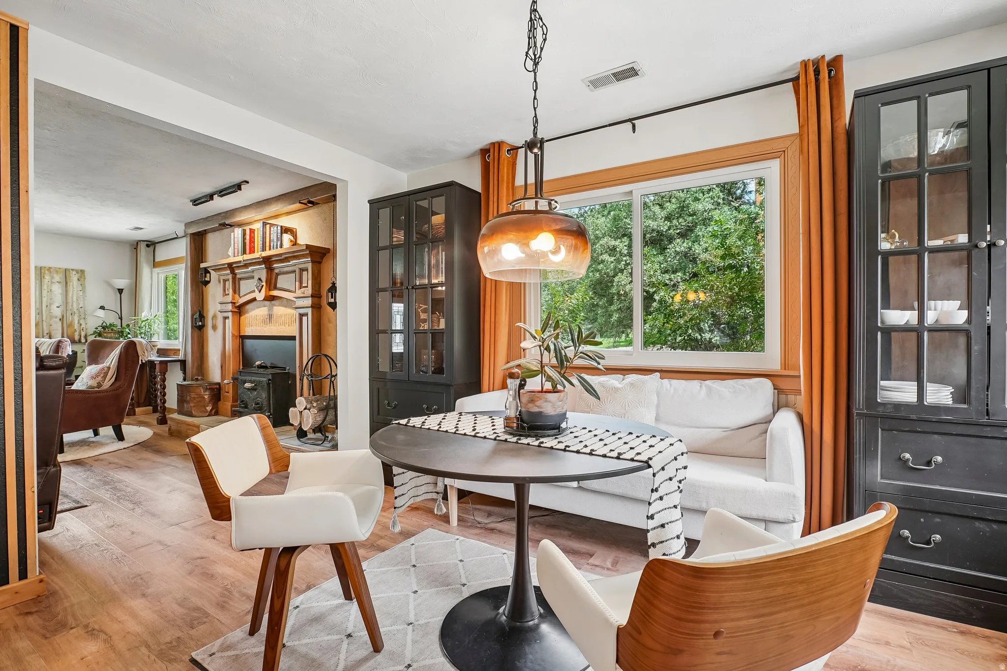 Wood-finish flooring, built-in display cabinetry, and a prominent window with a wooden frame
