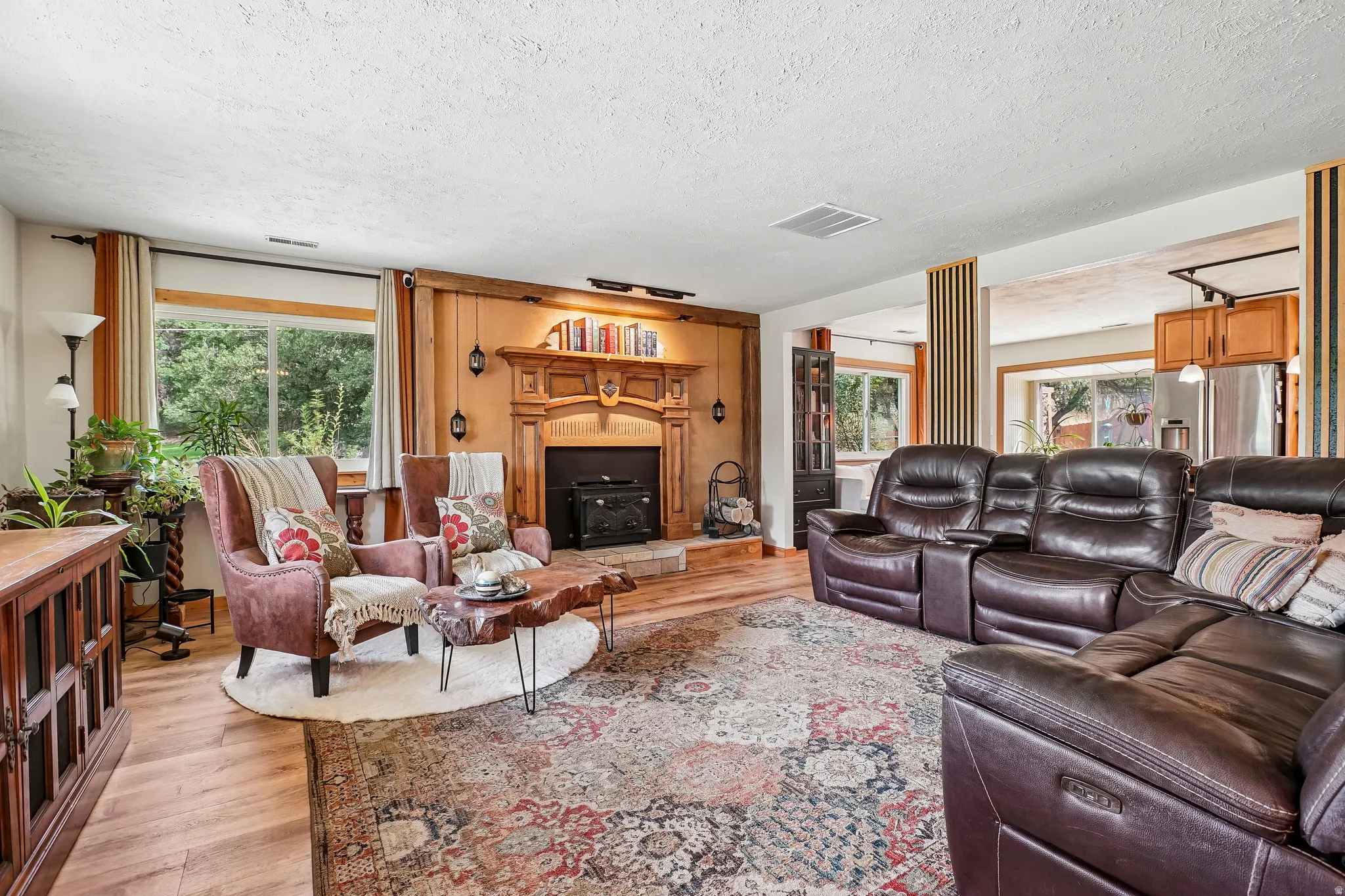 Living space featuring a wood-finish floor and a decorative fireplace with a carved wood mantel