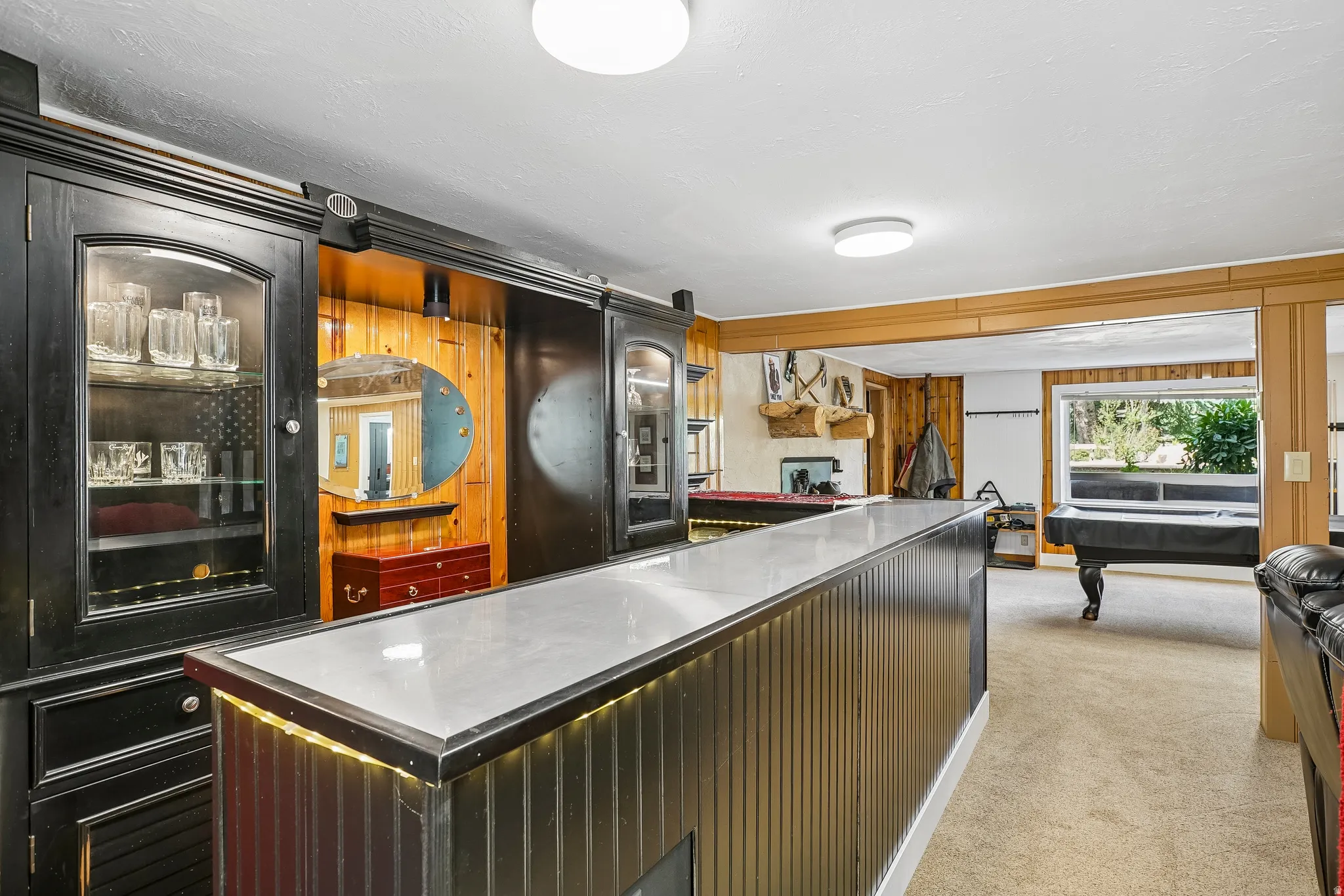 Built-in bar with glass-front cabinetry and integrated lighting