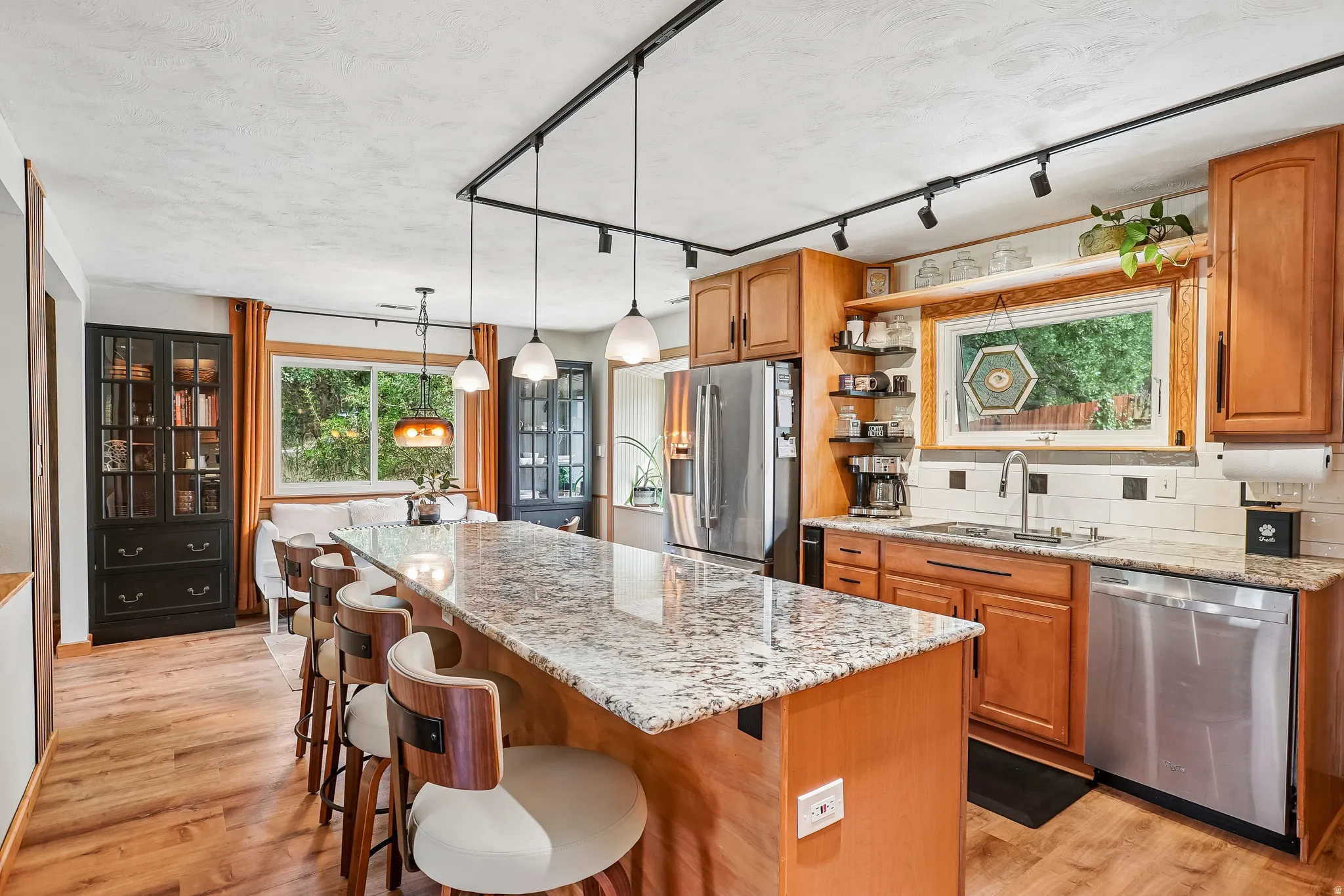 Kitchen featuring wood-finish flooring, granite countertops, and stainless steel appliances