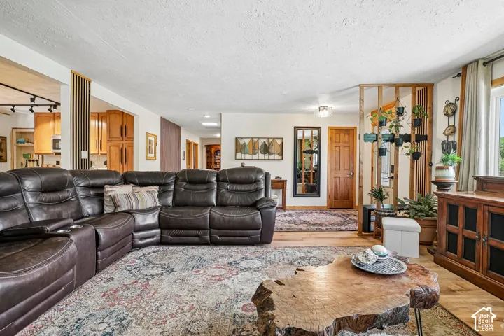 Open concept living area with wood-finish flooring, built-in wooden room divider, and natural wood trim around windows