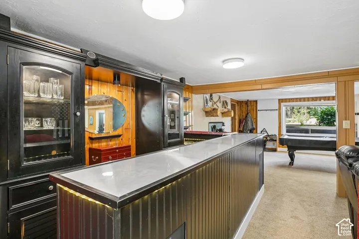 Sophisticated kitchen featuring a large waterfall-edge island with ribbed panel cabinetry, white quartz countertops, and integrated under-island lighting