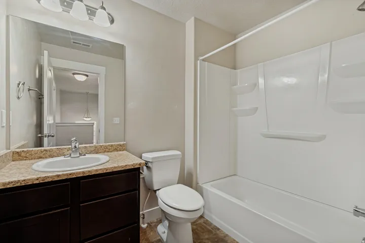 Bathroom featuring a vanity with a light-colored countertop, a white oval sink, and a dark wood-finish cabinet