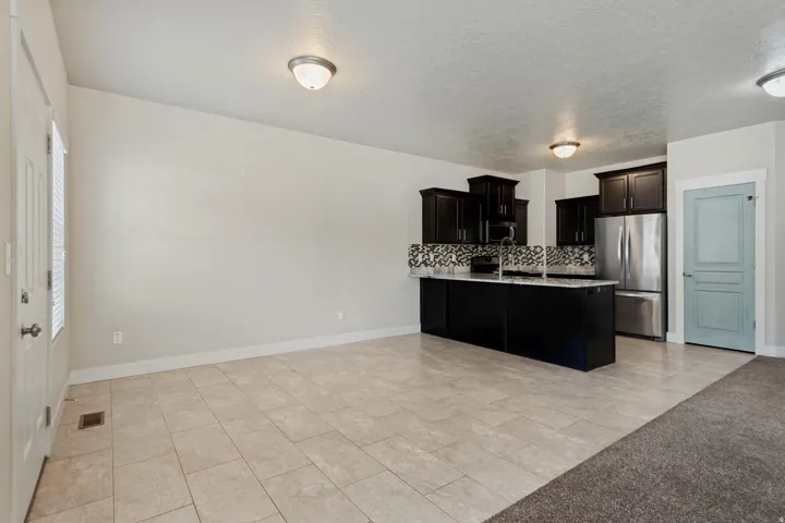 Kitchen featuring dark wood cabinetry, stainless steel appliances, and a mosaic tile backsplash