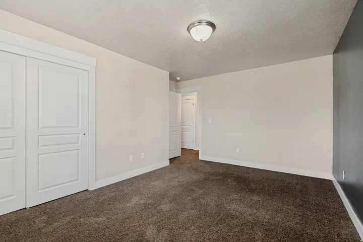 Neutral-toned walls, textured ceiling, and flush mount lighting