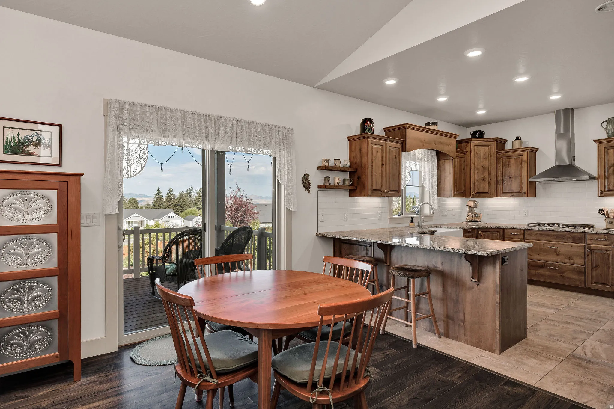 Kitchen featuring wood cabinetry, an island with seating, a gas range, and a stainless steel vent hood