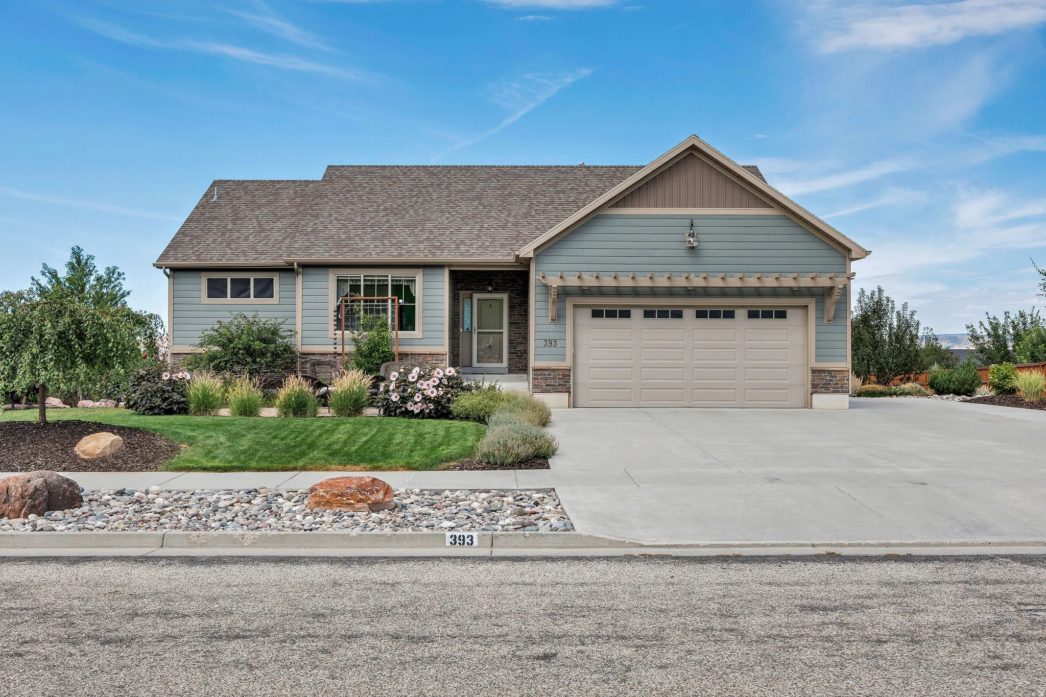 Single-story residence featuring siding, stone accents, and a dual garage