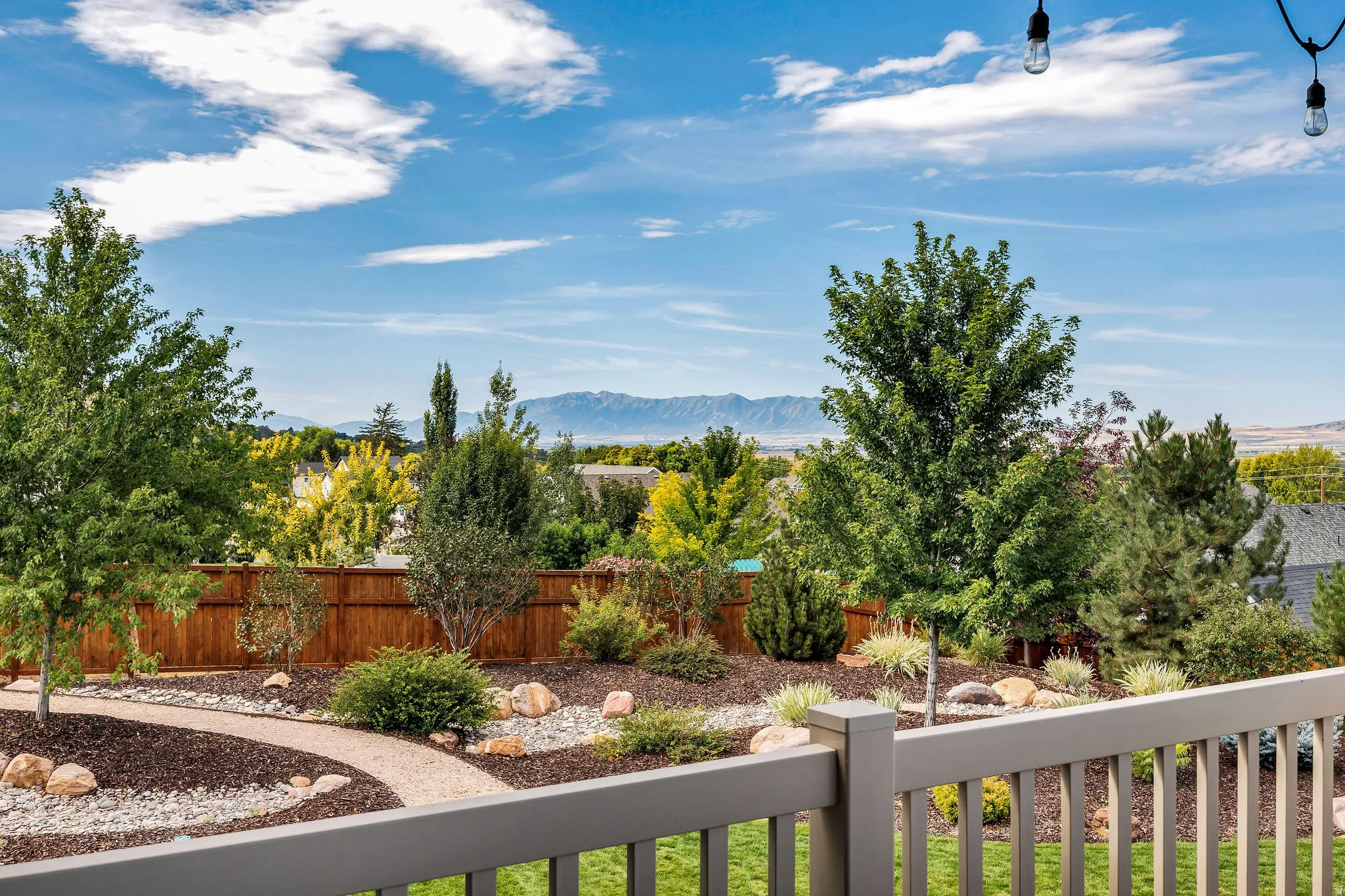 Expansive backyard with a wooden fence, landscaped garden beds, and gravel pathways