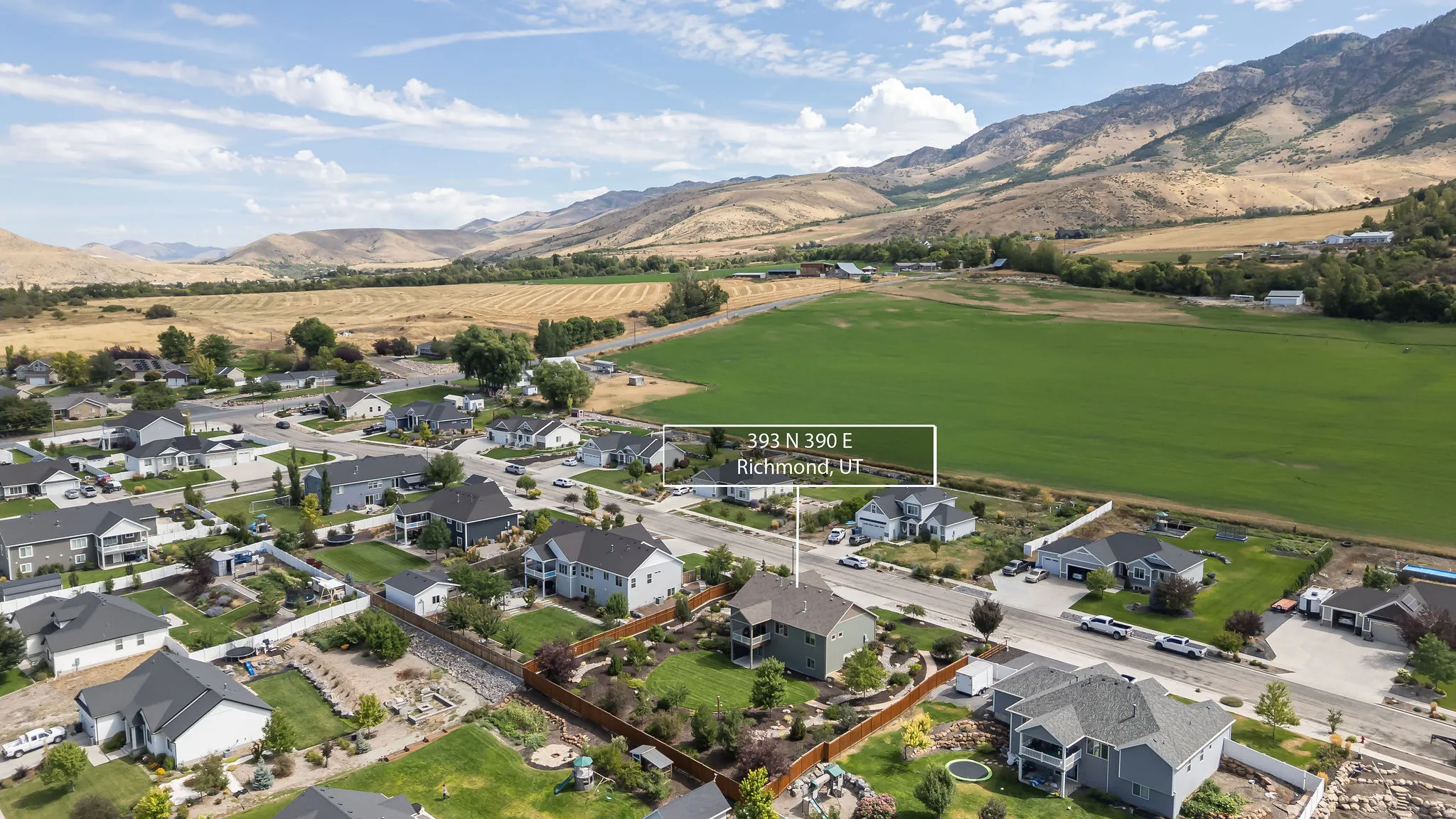 Residential property featuring a fenced backyard, mature landscaping, and an adjacent community