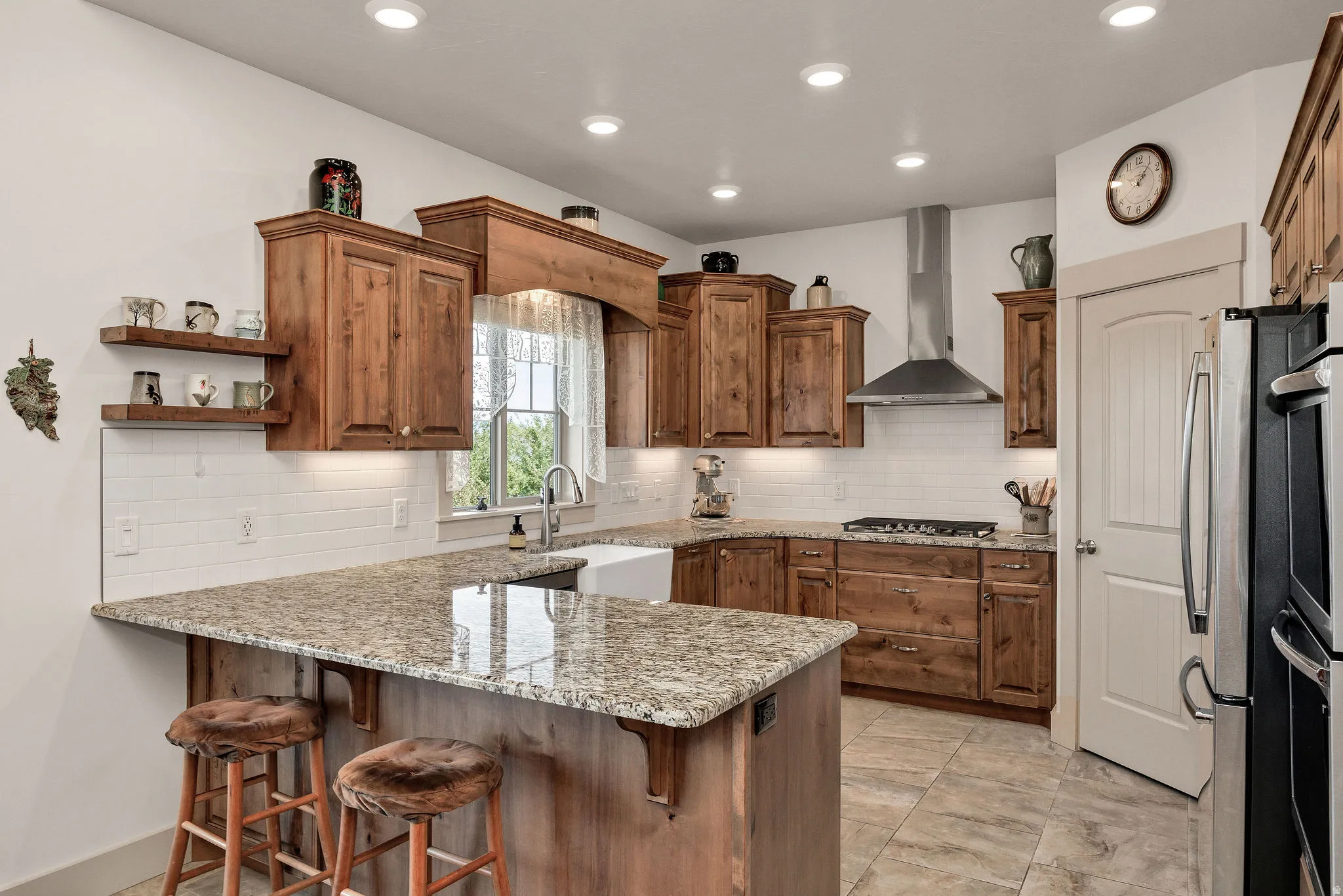 Kitchen featuring wood cabinetry, light-toned countertops, a white farmhouse sink, and stainless steel appliances