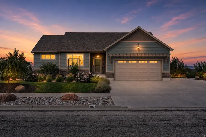 Siding exterior with stone accents, a two-car garage, and a concrete driveway