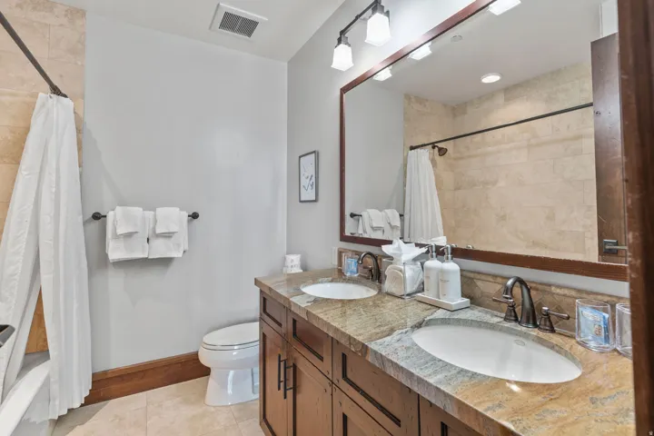 Dual vanity with granite countertop, integrated sinks, and bronze-finish fixtures