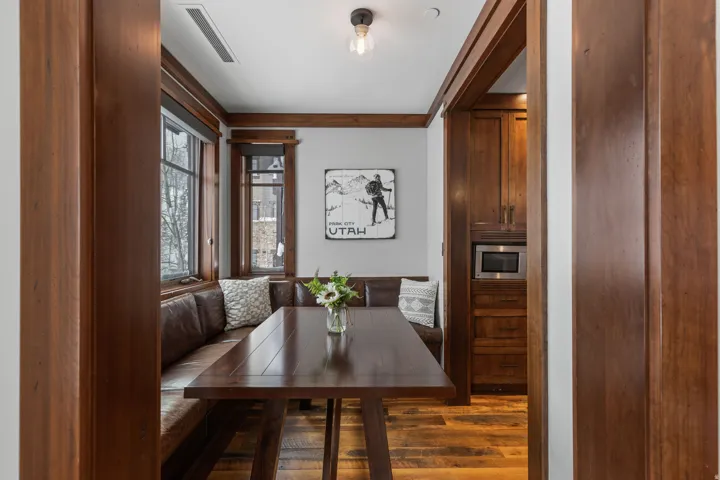Wood-finish flooring, built-in banquette seating, wood-framed windows, wood-paneled walls, and built-in microwave