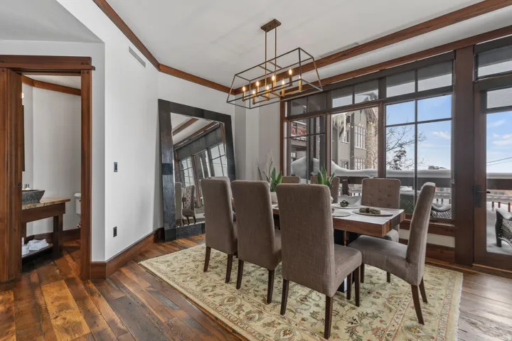 Hardwood flooring, wood trim accents, large windows, contemporary linear chandelier, and a powder room with a vessel sink