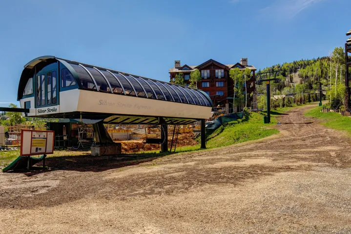 Ski lift station with a multi-story building and forested hillside in the background