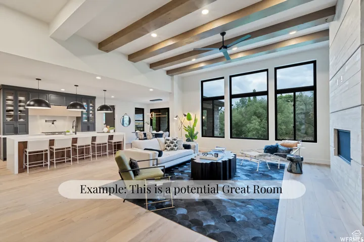 Expansive living area with wood-finish flooring, exposed ceiling beams, and a modern fireplace