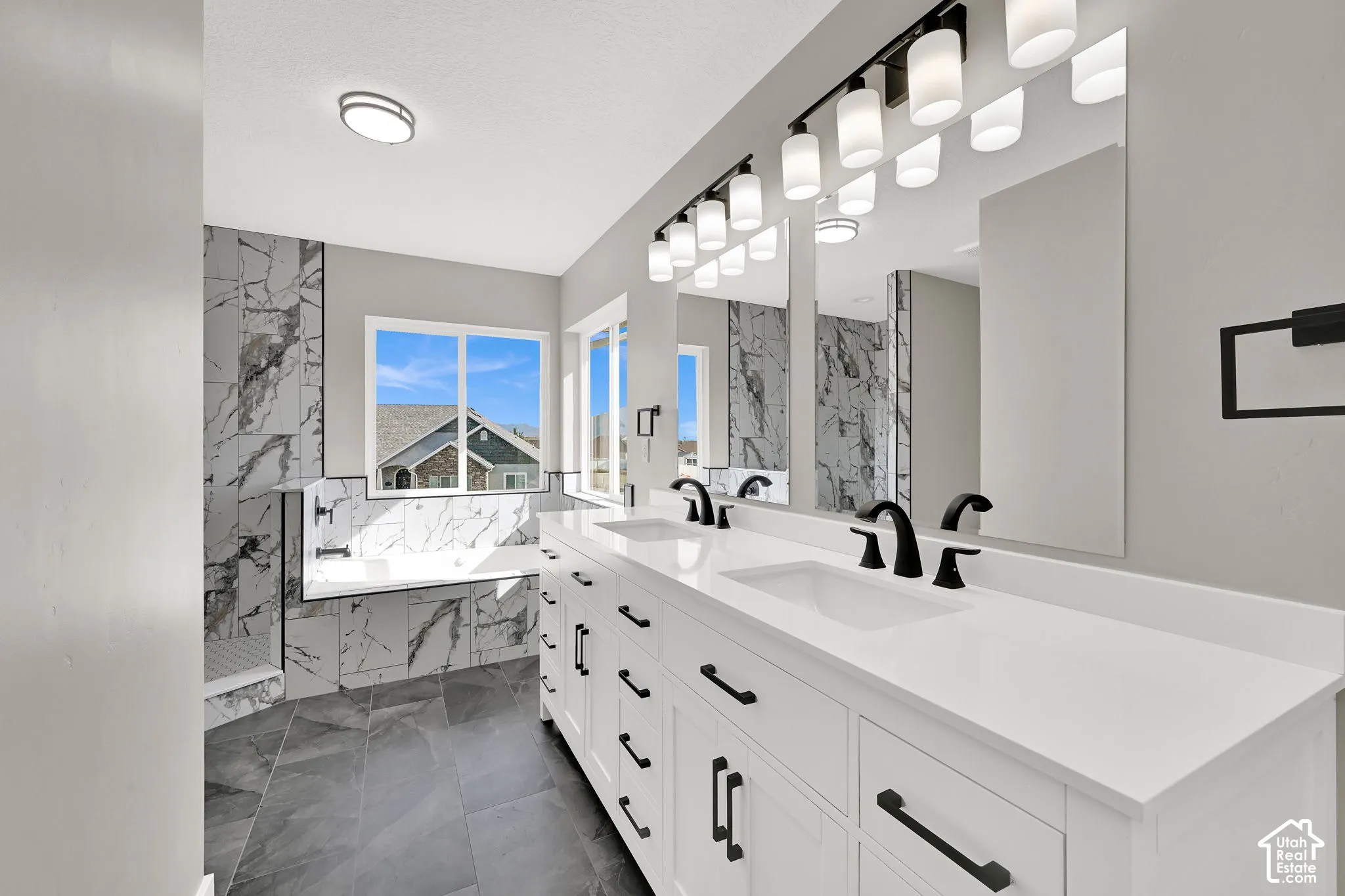 Spa-like primary bathroom features a large vanity with double sinks.