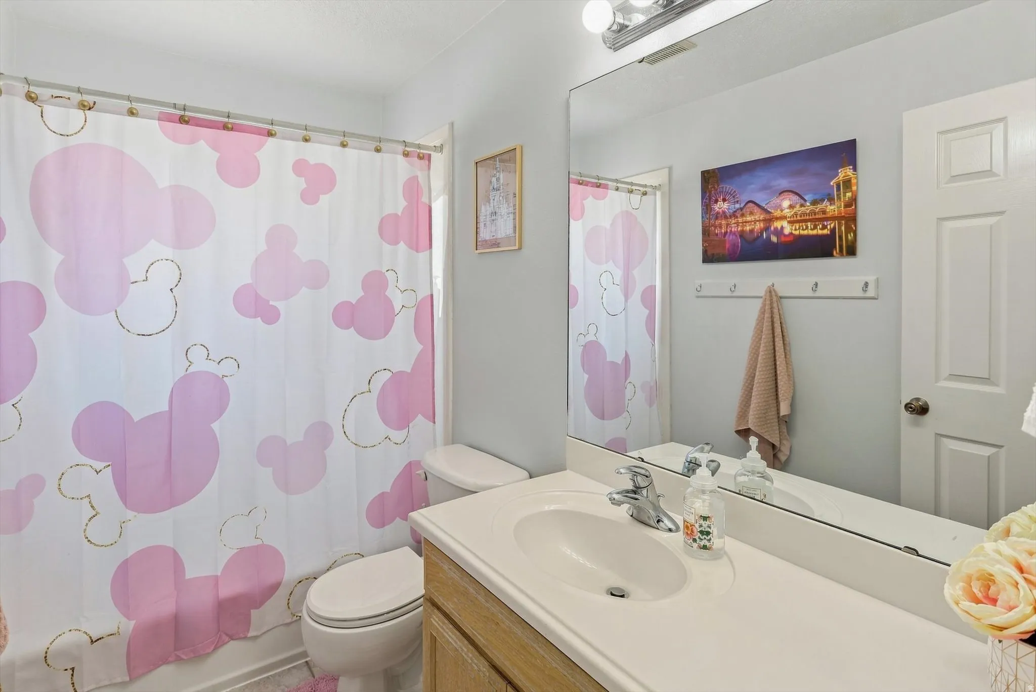 Bathroom featuring a built-in vanity with an integrated sink, a large wall-mounted mirror, and overhead strip lighting