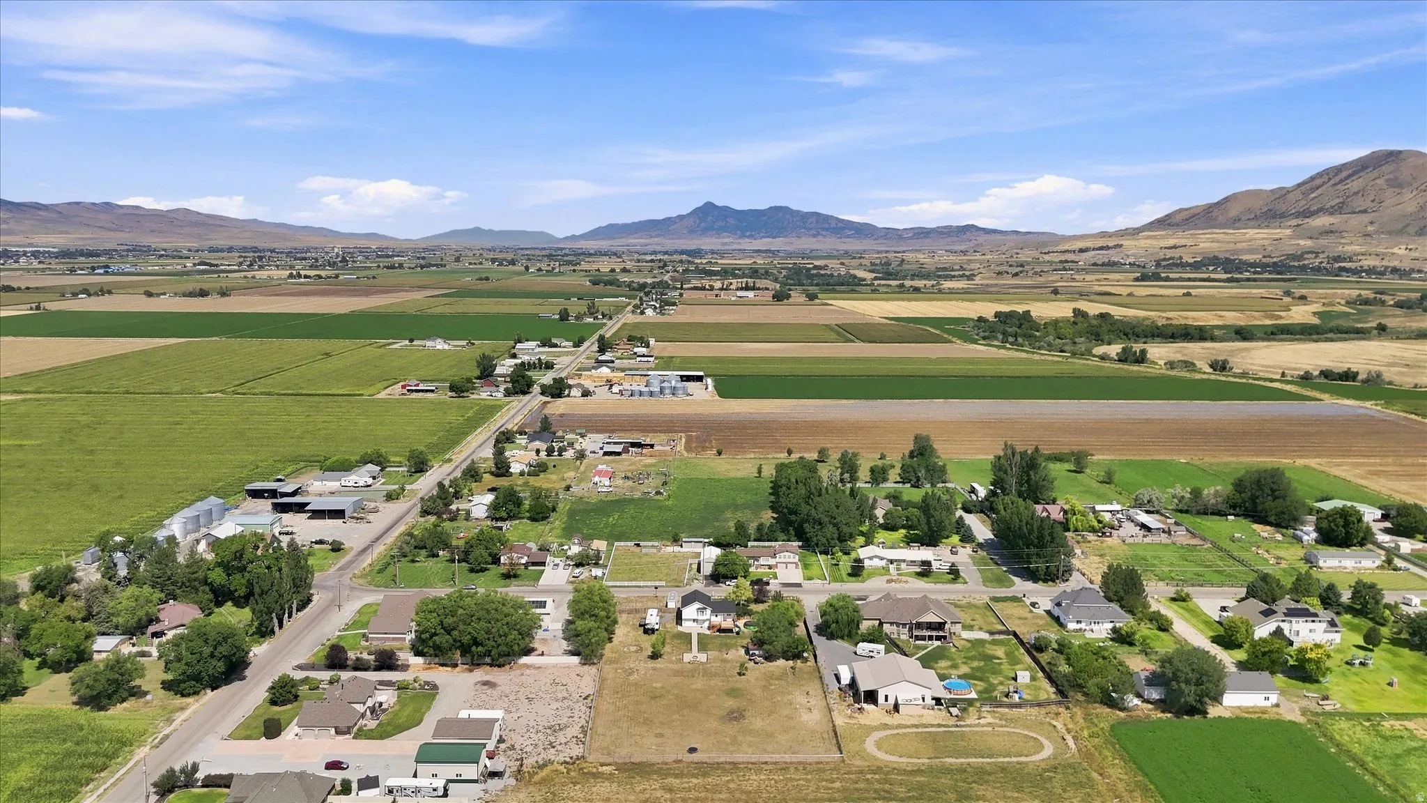 Expansive rural landscape featuring a mix of agricultural fields and residential properties