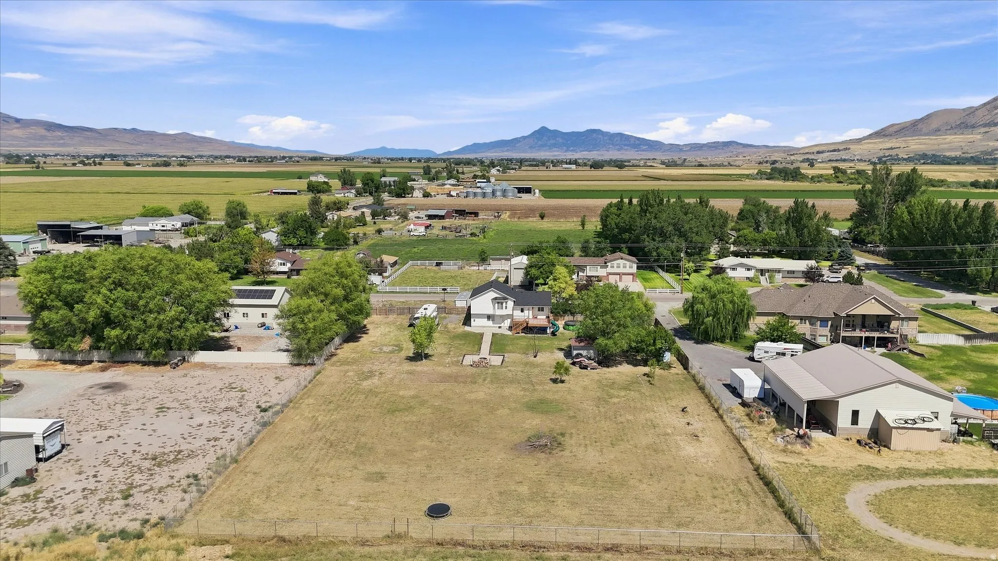 Expansive lot with a two-story residence, mature trees, and mountainous scenery