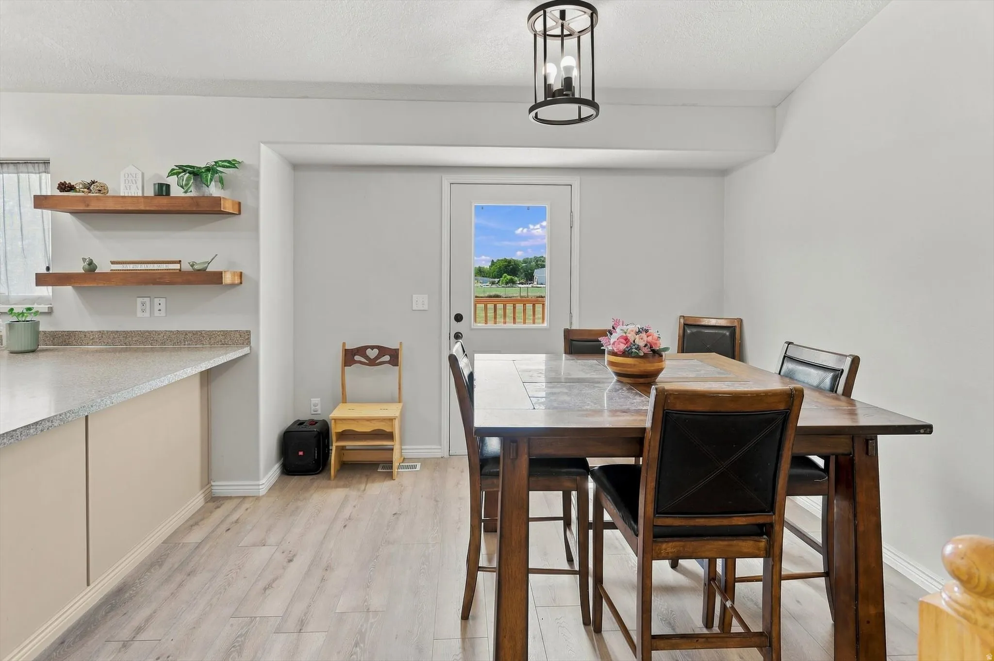 Wood-finish flooring, built-in open shelving, and a modern ceiling light fixture