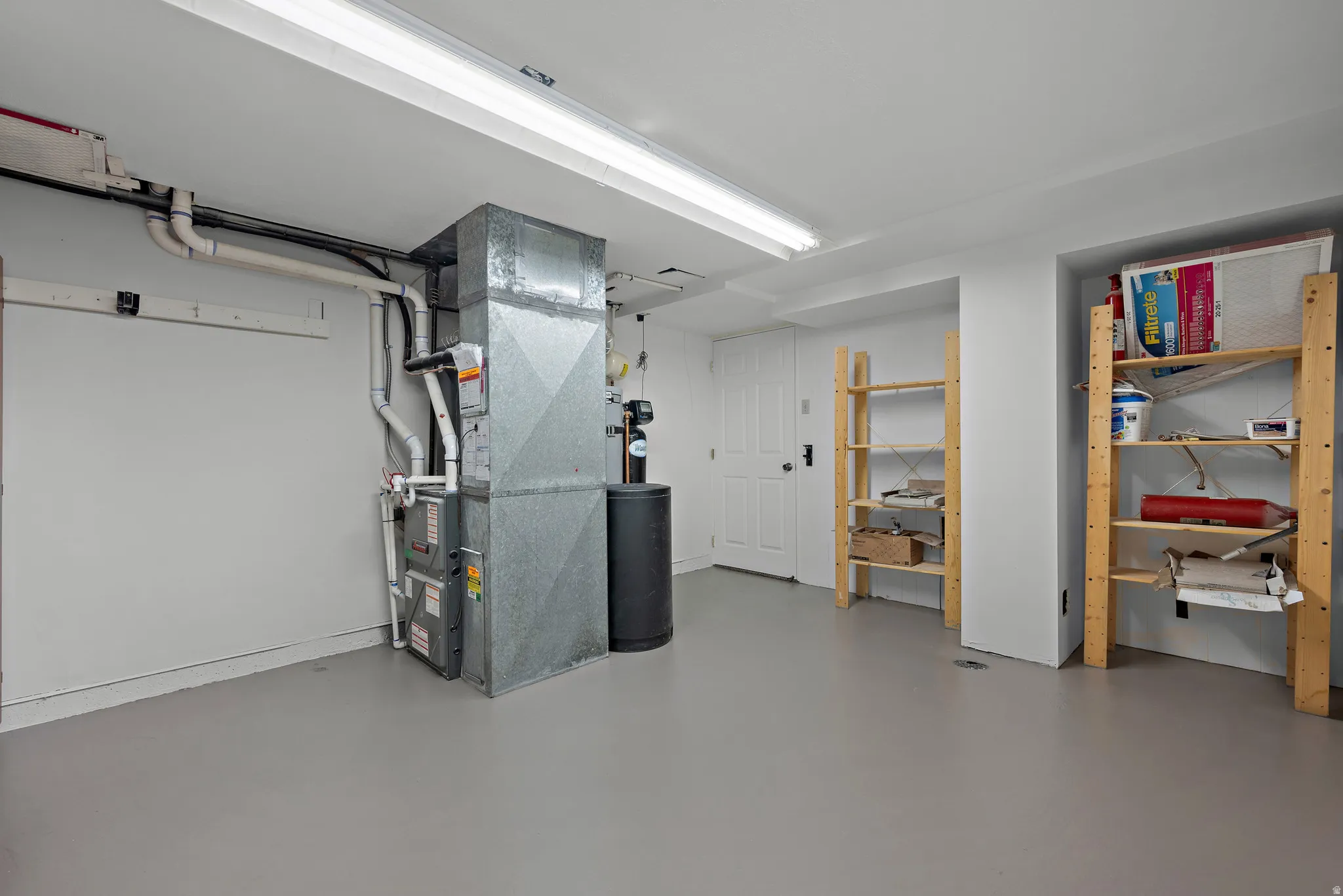 Utility area featuring a furnace system, water heater, and painted concrete flooring