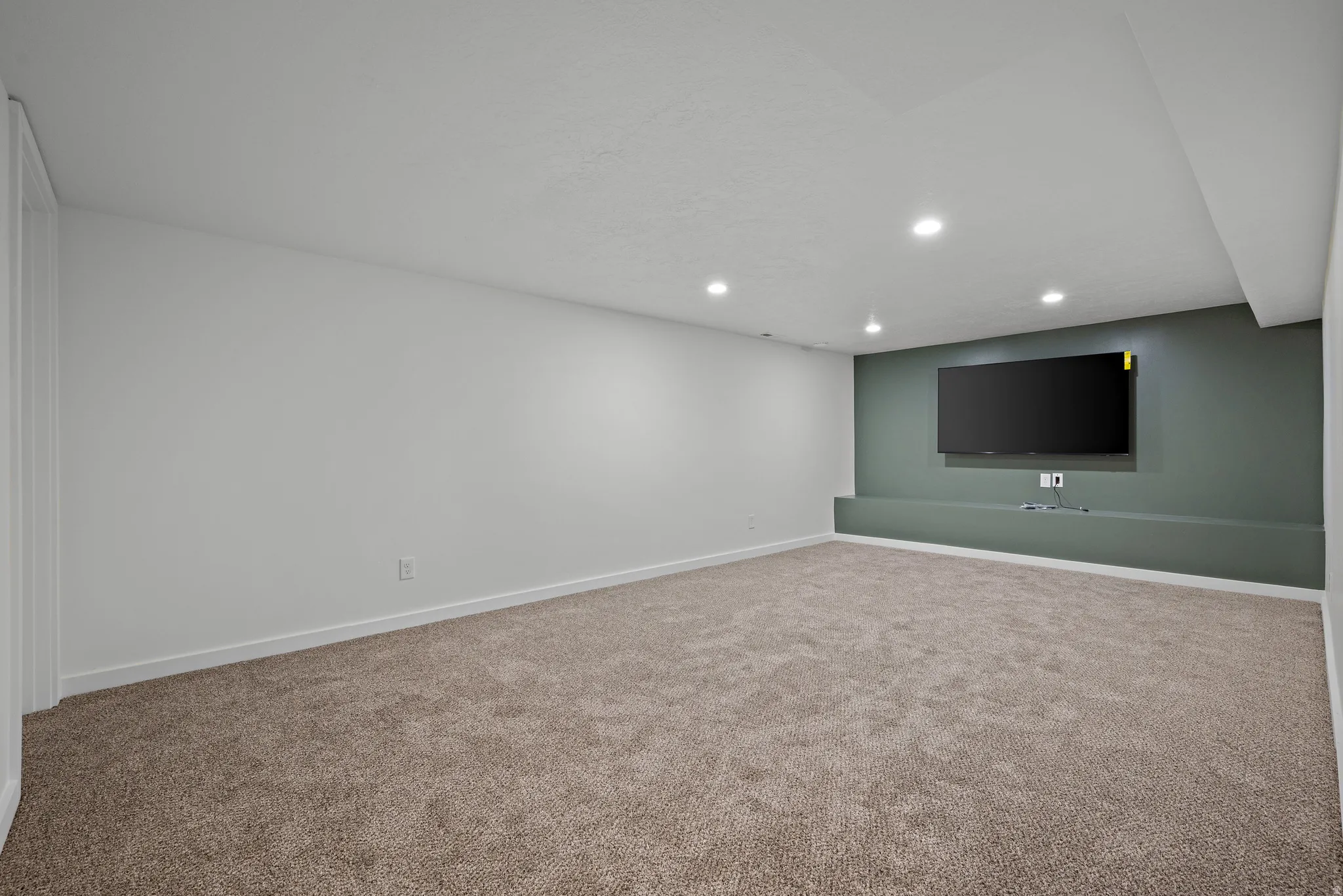 Recessed lighting, carpeted flooring, and a built-in media console