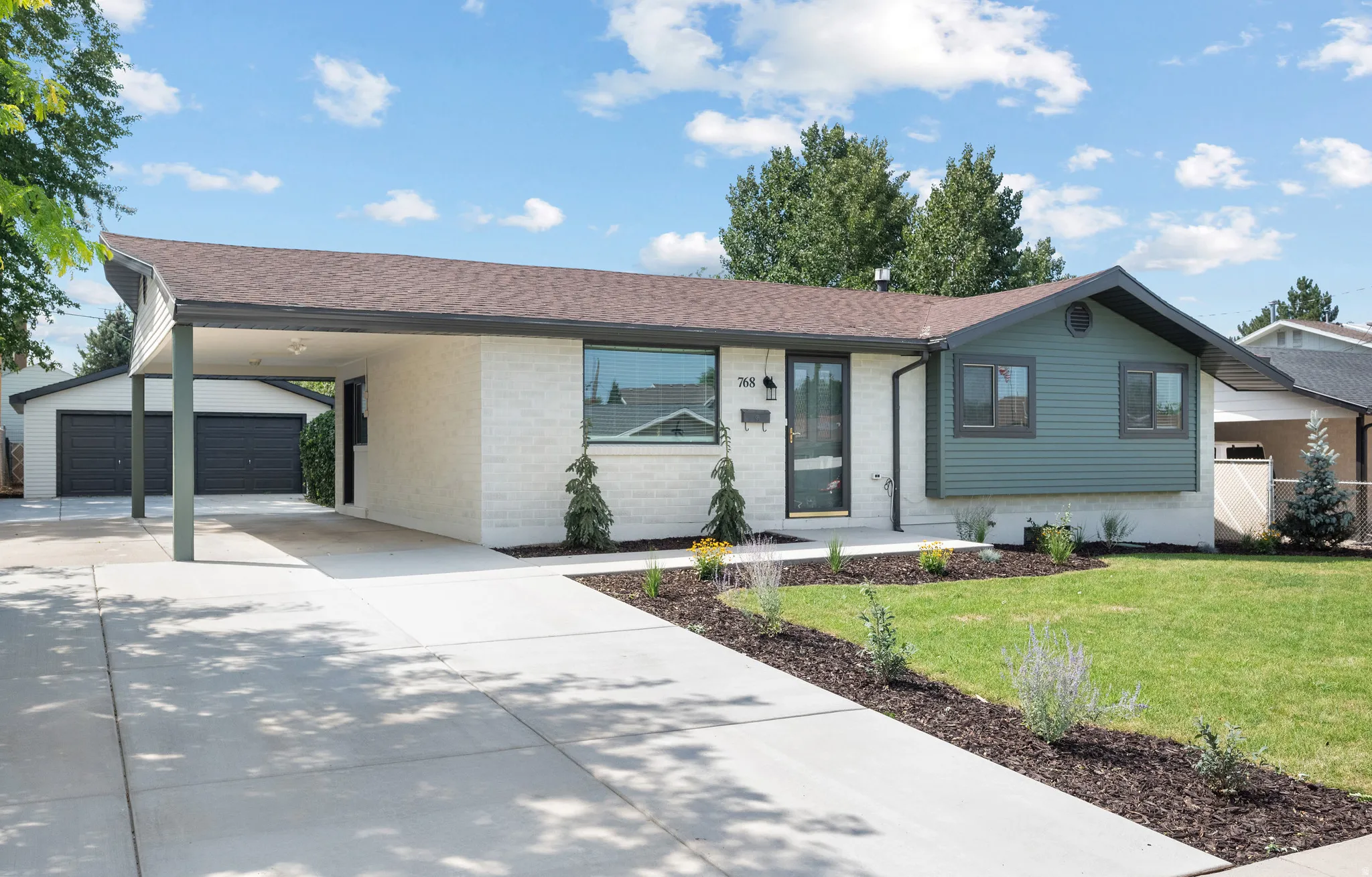 Contemporary exterior with a covered carport, attached garage, and a concrete driveway