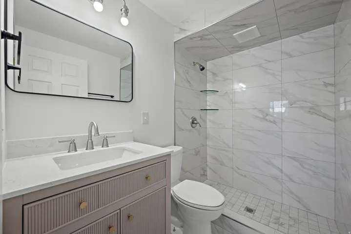 Vanity with a light-toned countertop, under-mount sink, and brushed nickel faucet