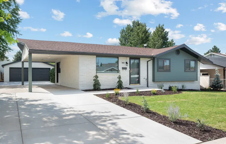 Contemporary exterior with a covered carport, attached garage, and a concrete driveway
