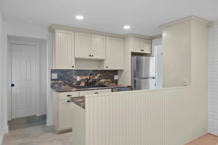 Cream-painted cabinetry with beadboard paneling and dark hardware