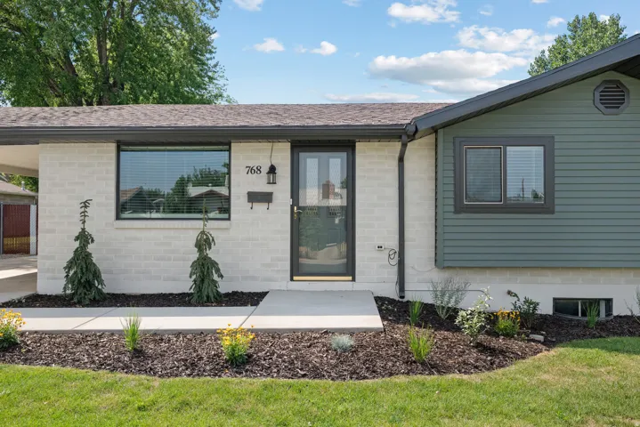 Exterior featuring painted brick and horizontal siding, a covered entry, and a covered carport