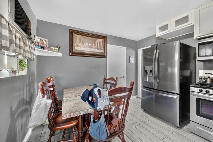 Wood-finish flooring with a stainless steel refrigerator, microwave, and range