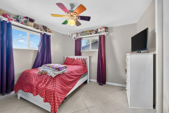 Recessed ceiling fan with integrated lighting, multiple windows, tile flooring, and neutral wall tones